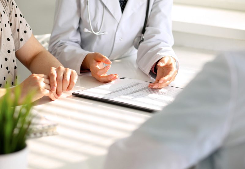 Doctor-reviewing-medical-form-with-patient