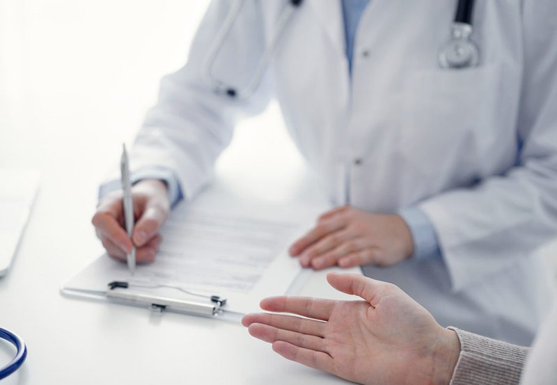 Doctor-taking-notes-during-patient-consultation Doctor-taking-notes-during-patient-consultation