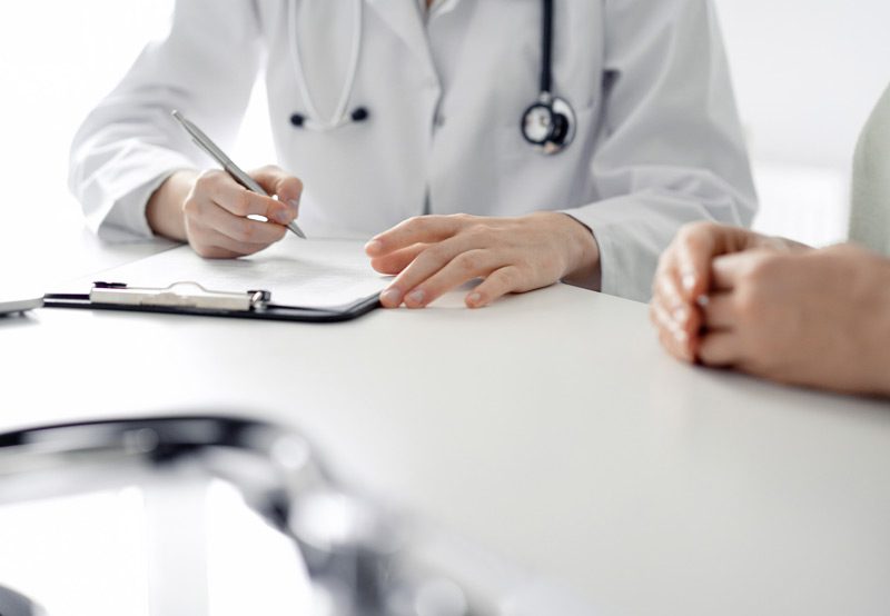 Doctor-writing-notes-during-patient-consultation