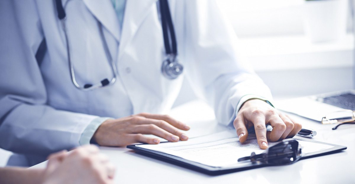 Physician-reviewing-medical-chart-with-patient Physician-reviewing-medical-chart-with-patient