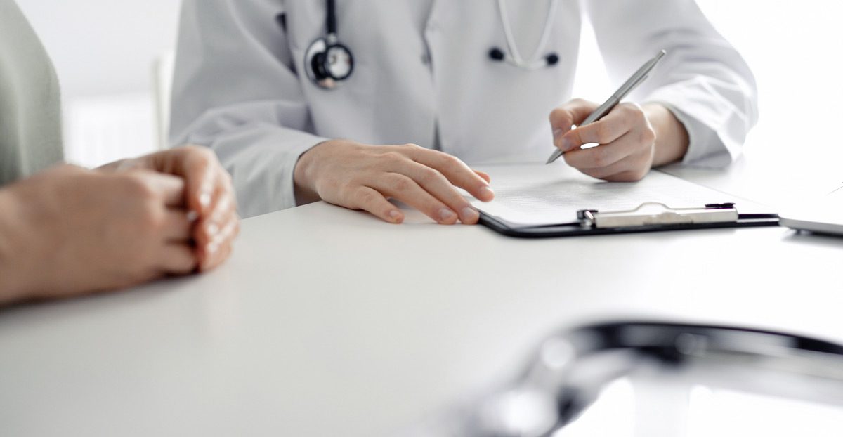 Physician-taking-notes-during-patient-visit