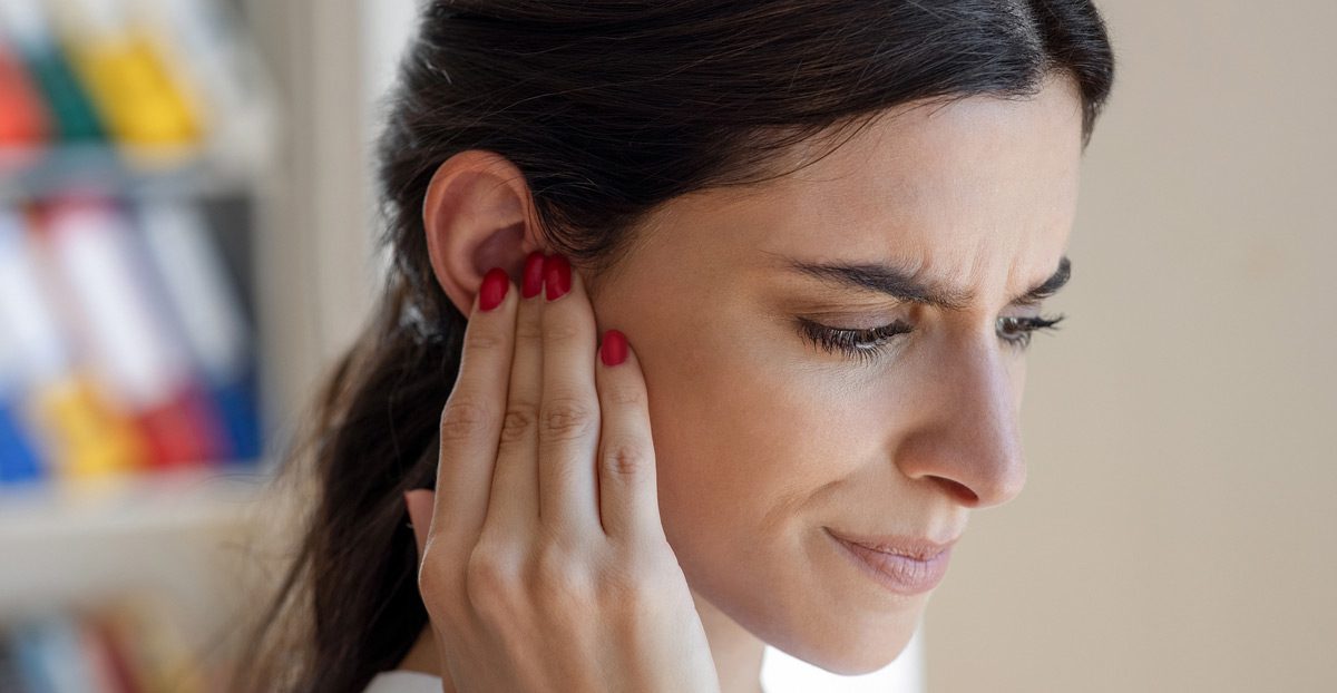 Woman-touching-ear-with-discomfort